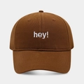 Detail of white hey embroidery on tan cotton baseball cap with high texture finish - Coffee