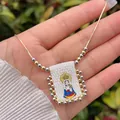 Macro detail of 18K gold plated beaded snake chain with cartoon Virgin Mary pendant - Madonna and Child