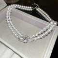 Detail of double-layer pearl necklace with zircon-encrusted silver Saturn pendant - Double Layer Pearl Saturn Necklace / Silver-White