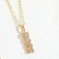 Detalle del colgante BOSS dorado con circonitas brillantes en collar de moda - BOSS