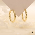 Strukturierte goldene Creolen mit gehämmerter Oberfläche auf weißer Karte präsentiert - Gold Hammerschlag-Ring