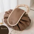 Nahaufnahme der braunen Kordelzug-Kulturtasche mit rundem Griff und Tea Break-Logo - Khaki