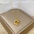 Golden double interlocking rings necklace with screw motif on beige leather stand - Screw Pattern Double Ring Style (8882) / Gold