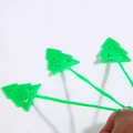 Close-up of flexible green silicone Christmas tree toys with long tails on white background - Green Christmas Tree