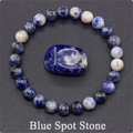 Detailed macro view of natural blue spot stone beads and polished stone on grey surface - Blue Spot Stone