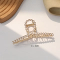 Detail view of the 11.5cm gold alloy pearl hair claw clip on a minimalist background - Cross Pearl