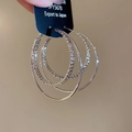 Close-up of silver-plated multi-layer hoop earrings with textured and smooth finishes - Silver
