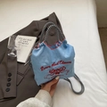 Bolso de nailon azul claro con bordado rojo y asas tejidas en blanco y negro - Azul