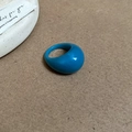 Detailansicht eines blauen Harzrings auf weißer Keramik und braunem Kraftpapier - Blau