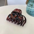 Close-up of a large brown tortoiseshell claw clip with a glossy finish on white surface - Glossy Red Brown
