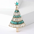 Macro shot of sparkling rhinestone Christmas tree brooch with green crystals and gold finish - Green + White