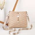 Detail of beige quilted crossbody bag featuring a cat-shaped metal clasp and pearl charms - Khaki