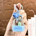 Cartoon rugzak sleutelhanger met groene kikker figuur en blauwe bel hanger detail - Rugzak Kikker-Blauw