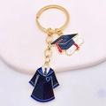 Detail of graduation keychain featuring academic gown, cap, and diploma charms on a gold ring - Navy White Collar Gown Doctor Hat Style (JE0922B)