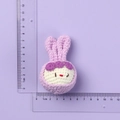 Handmade crochet pink bunny doll keychain head with purple flower detail and white accents - Purple Rabbit Ear Doll Head
