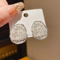 Macro shot of silver woven bow earrings with sparkling cubic zirconia on 925 silver posts - 925 Sterling Silver Earring Post - Silver Irregular Hollow Weave