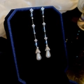 Detalle macro de pendientes de trébol con perlas de gota en un estuche de joyería de lujo - Plata (Pin de plata)
