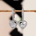 Elegantes pendientes de corazón plateados con circonitas brillantes sobre una rama - Oro Blanco