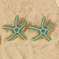 Detailed close-up of starfish earrings with green and white crystals on sand - Green Medium KC Gold Starfish Style (WEH5247)