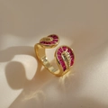 Zweilagiger vergoldeter offener Ring mit magenta Zirkonsteinen auf Seidenstoff - Gold