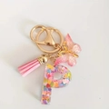Golden letter P resin keychain with pink tassel, butterfly charm and colorful heart sequins - Letter P