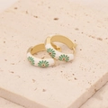 Detail view of gold earrings with green daisy pattern and white enamel finish - White