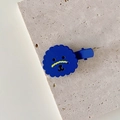 Close-up of a cute blue cartoon dog hair clip with matte finish on a stone tray - Blue Puppy