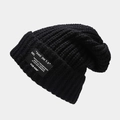 Detailed view of black chunky knit beanie featuring ribbed texture and letter patch - One Size / Black