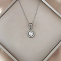 Macro shot of silver halo pendant necklace with zircon stone on silk fabric - Silver Clear Rhinestone
