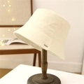 Cremefarbener Fischerhut mit strukturierter Optik und Fransenrand auf einem Vintage-Ständer - M (56-58cm) / Cremeweiß
