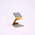 Golden Z-shaped metal jewelry display stand with grey anti-slip pads on white base - Gray