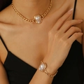 Detailed shot of baroque pearl pendant necklace and matching golden bracelet set on a model - Gold Cuban Chain Pearl 2-Piece Set