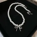 Close-up of pearl choker necklace featuring a metallic bow pendant in a gift box - Bowknot Pearl Necklace
