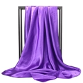 Close-up of bright purple silk satin headscarf draped over a black metal display frame - Purple