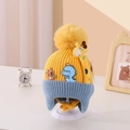 Close-up of knit toddler hat with colorful dinosaur patches and a yellow pom-pom - Giraffe Orange Yellow