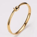 Polished golden stainless steel snake bangle with 18K drip oil eye detail in gold finish - Black Eye