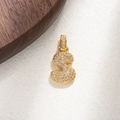 Detailed view of number 3 pendant with micro-paved zircons on a golden surface - S
