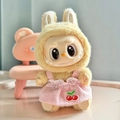 Labubu plush doll in yellow fluffy coat and pink cherry embroidered dress on pink seat - Pink Cherry Suspender Strap / First And Second Generation Keychains Are Compatible With La Cloth Dolls. Dolls Not Included.