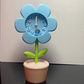 Sky blue flower-shaped desk alarm clock with a green stem and cream-colored base - Blue Flower Alarm Clock