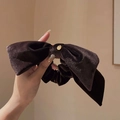 Close-up of velvet bow hair scrunchie in dark brown with a small golden charm detail - Brown