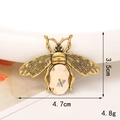 Detail shot of a vintage gold bee charm with champagne gemstone and size markings - Gold/Champagne Bee