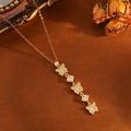 Detailed close-up of golden butterfly pendant necklace with zircon on vintage background - Gold Small Butterfly Tassel