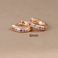 Macro shot of 6mm rose gold huggie hoop earrings with colorful inlaid crystals - 6mm / Rose Gold