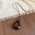 Détail du collier pendentif rétro en résine avec perle léopard sur fond bois rustique - 23# Collier-Café