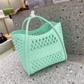 Detail view of the mint green hollowed-out jelly tote bag with dual handles on a stone surface - Mint Green