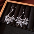 Detailed macro view of 18k gold plated teardrop tassel earrings with zircon crystals - Earring Hooks - Silver