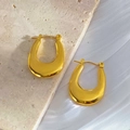 Detailed view of polished 18K gold plated U-shaped chunky hoop earrings on silk fabric - Gold 122/U-shaped