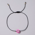 Handgefertigtes schwarzes Webarmband mit pinker Drachenfrucht-Perle und goldfarbenen Details - Obstmotiv