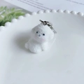 Cute white flocked puppy keychain with silver metal clasp on a decorative white plate - Blushed Style 2