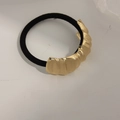 Minimalist gold textured metal hair tie with wavy brushed finish on black elastic band - Curved Stripe Gold